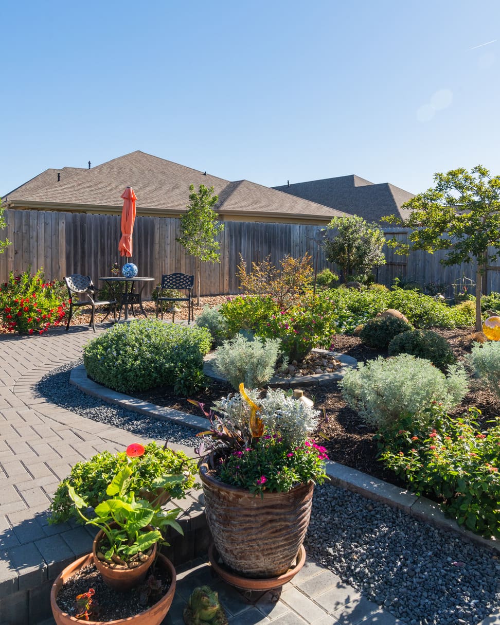 Outdoor living space with pergola and fire feature by Theiss Landscape Works
